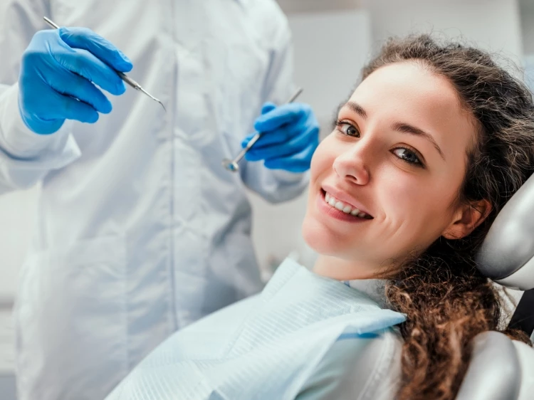 Uśmiechnięta pacjentka obok stomatologa